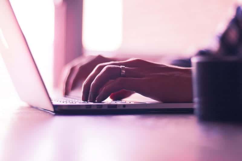 Zoomed in hands working on a laptop