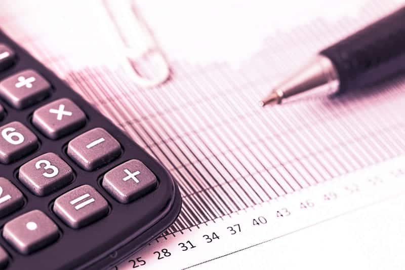 closeup of a calculator and paperwork to illustrate a piece sharing advice about MBA company sponsorship and tuition reimbursement